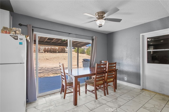 dining room with ceiling fan and a textured ceiling