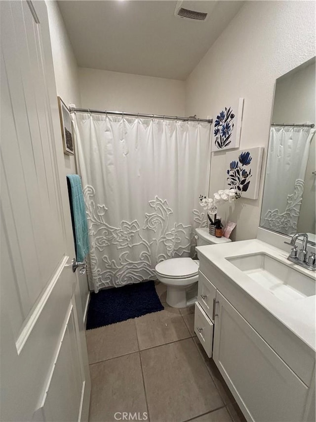 bathroom with tile patterned flooring, vanity, and toilet