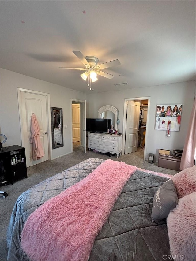 carpeted bedroom featuring ceiling fan and a spacious closet