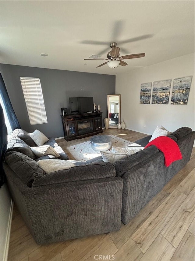 living room featuring ceiling fan and light wood-type flooring