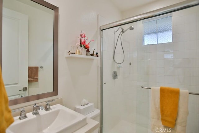 bathroom with walk in shower, sink, and toilet