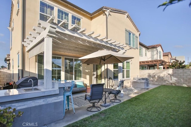 rear view of house with a pergola, a yard, and a patio area