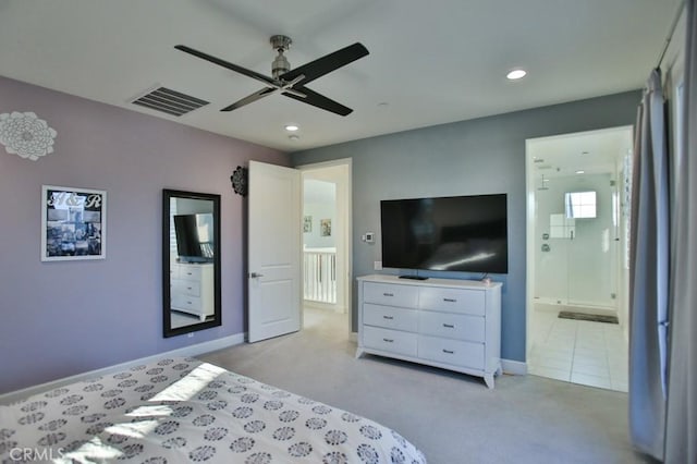 carpeted bedroom with ensuite bath and ceiling fan