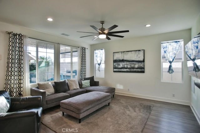 living room featuring ceiling fan and dark hardwood / wood-style floors