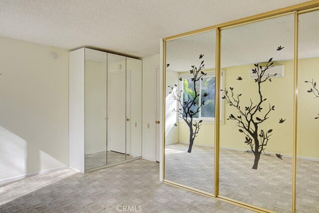 unfurnished bedroom featuring multiple closets, carpet flooring, and a textured ceiling