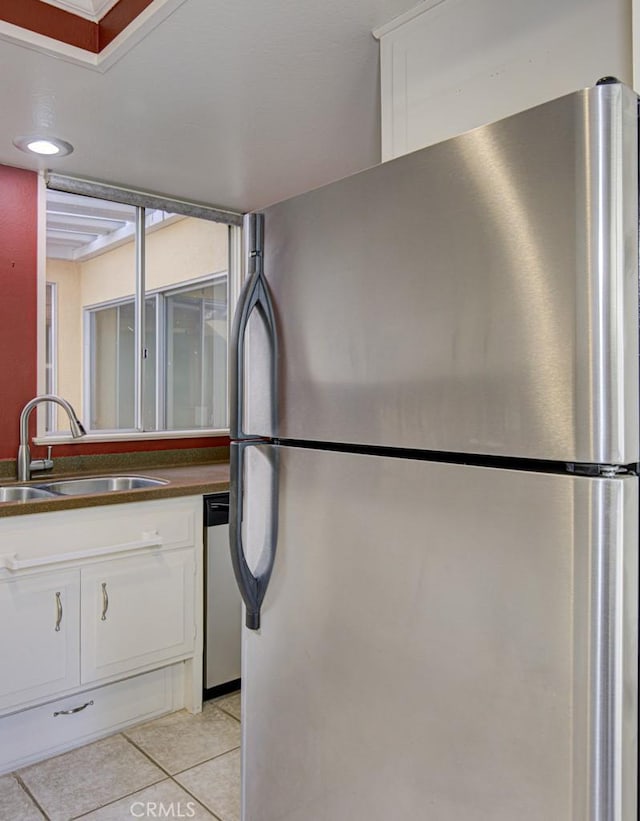 kitchen with white cabinetry, sink, light tile patterned floors, and stainless steel appliances