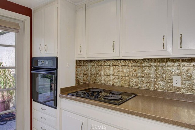 kitchen with tasteful backsplash, black appliances, and white cabinets