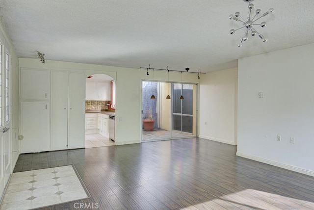 unfurnished room with wood-type flooring and a textured ceiling