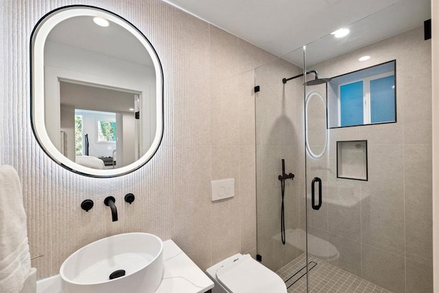 bathroom featuring vanity, a shower with door, and toilet