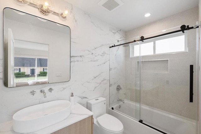 full bathroom featuring vanity, bath / shower combo with glass door, tile walls, and toilet