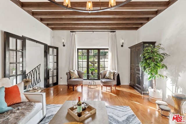 living room with french doors, beamed ceiling, and light wood-type flooring