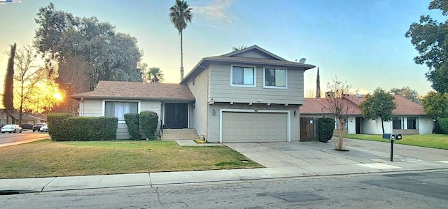 view of front of property with a garage and a lawn