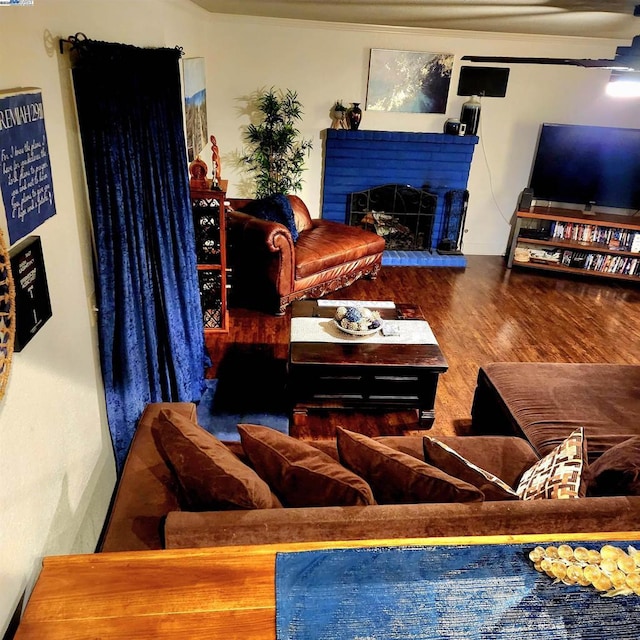 living room featuring wood-type flooring and a tiled fireplace