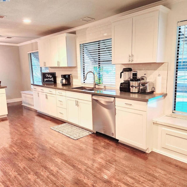 kitchen featuring sink, light wood-type flooring, ornamental molding, dishwasher, and backsplash