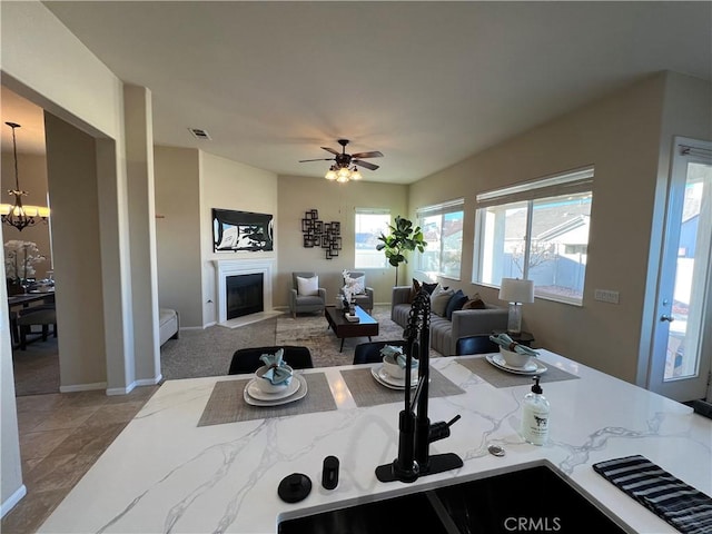 kitchen featuring ceiling fan with notable chandelier