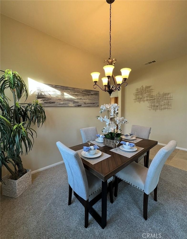 carpeted dining area with a chandelier