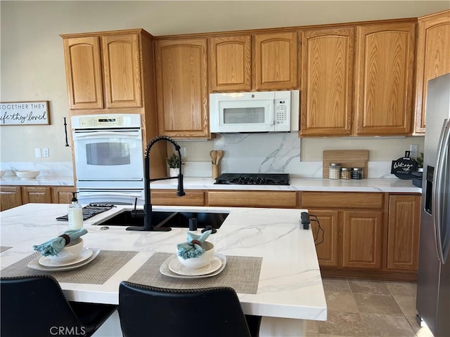 kitchen with tasteful backsplash, sink, and white appliances