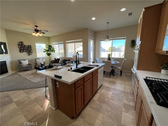 kitchen with sink, white appliances, ceiling fan, an island with sink, and decorative light fixtures