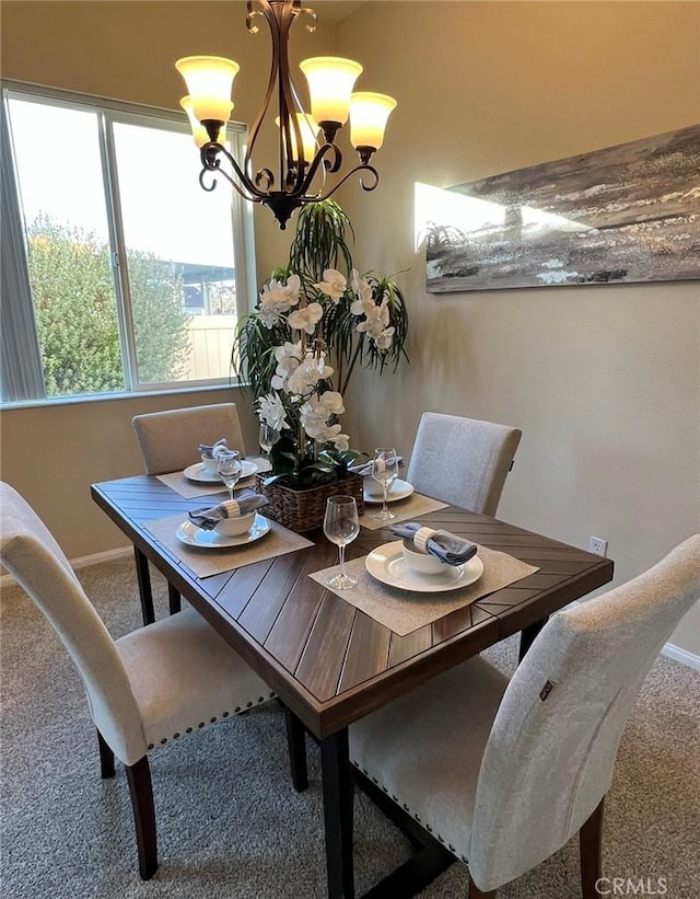 carpeted dining area featuring a chandelier