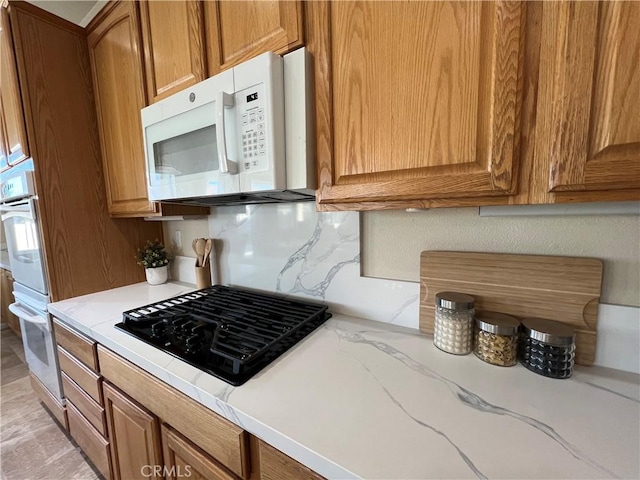 kitchen featuring backsplash and white appliances