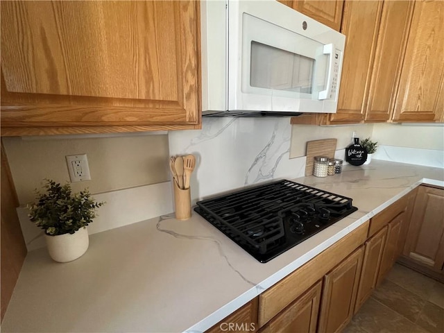 kitchen with tasteful backsplash and black gas stovetop