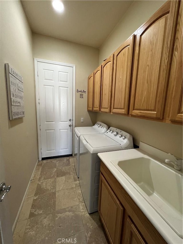 laundry room with cabinets, washer and clothes dryer, and sink