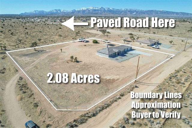 birds eye view of property featuring a mountain view, a desert view, and a rural view