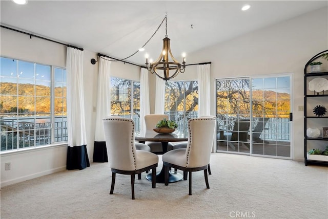 carpeted dining space with lofted ceiling and a notable chandelier