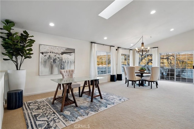 dining area featuring vaulted ceiling with skylight, carpet floors, and a notable chandelier