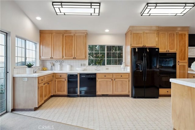 kitchen featuring tile countertops, decorative backsplash, and black appliances