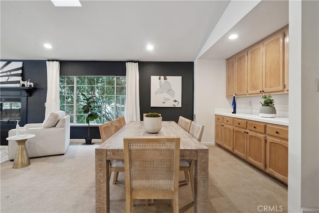 dining area with light carpet and a skylight