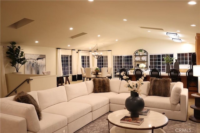 living room with vaulted ceiling and a notable chandelier