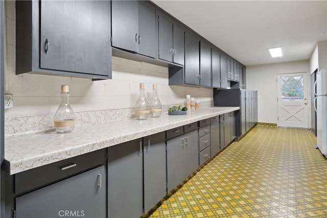 kitchen with tasteful backsplash and white fridge