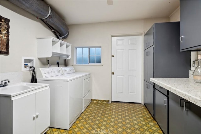 washroom featuring cabinets, sink, and washing machine and clothes dryer