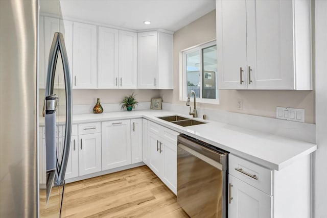 kitchen featuring appliances with stainless steel finishes, sink, and white cabinets