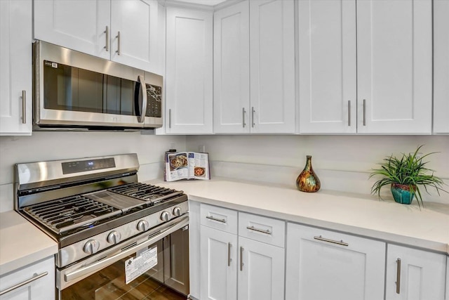 kitchen with stainless steel appliances, wood-type flooring, and white cabinets