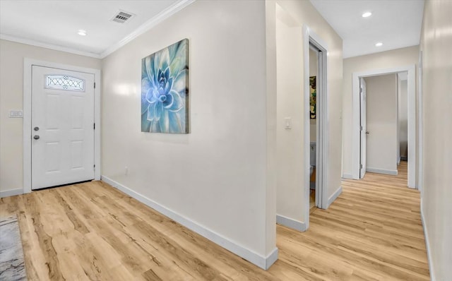 entrance foyer featuring ornamental molding and light hardwood / wood-style floors