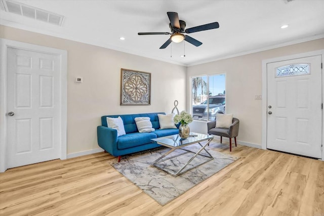 living room featuring crown molding, ceiling fan, and light hardwood / wood-style flooring