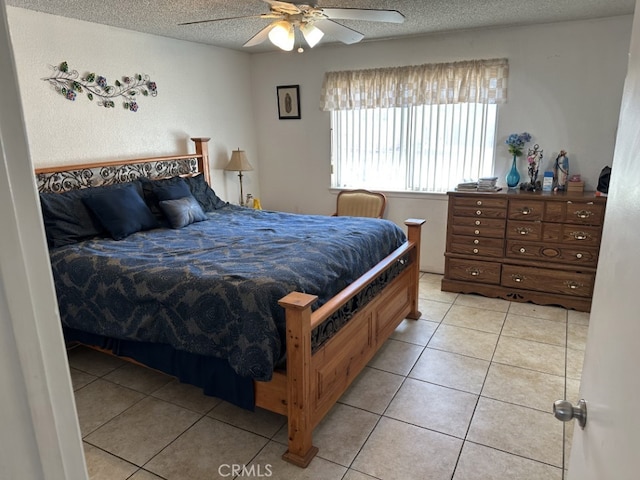 bedroom with light tile patterned flooring, ceiling fan, and a textured ceiling