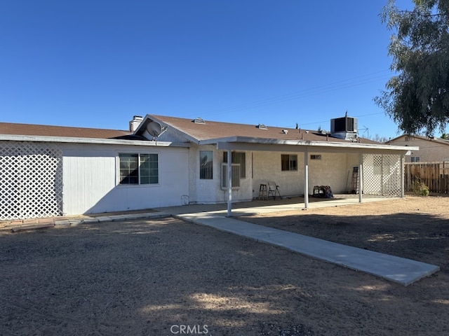 rear view of house featuring cooling unit and a patio area