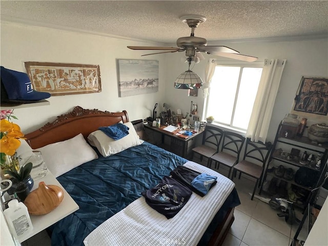 tiled bedroom with ceiling fan and a textured ceiling