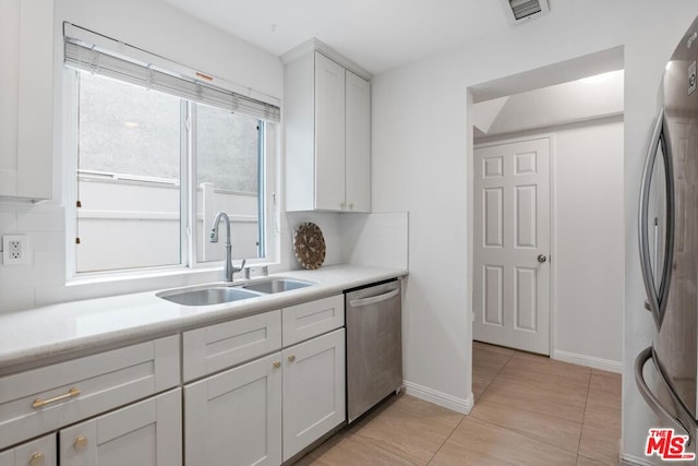 kitchen featuring tasteful backsplash, appliances with stainless steel finishes, and sink