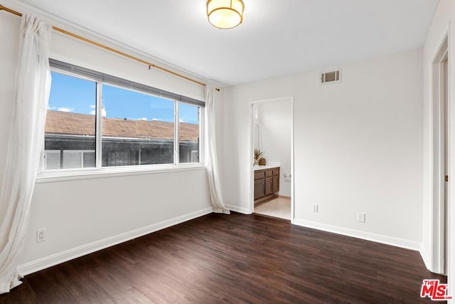 unfurnished bedroom with a mountain view, dark wood-type flooring, and ensuite bath