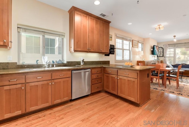 kitchen with sink, light wood-type flooring, dishwasher, kitchen peninsula, and a wealth of natural light