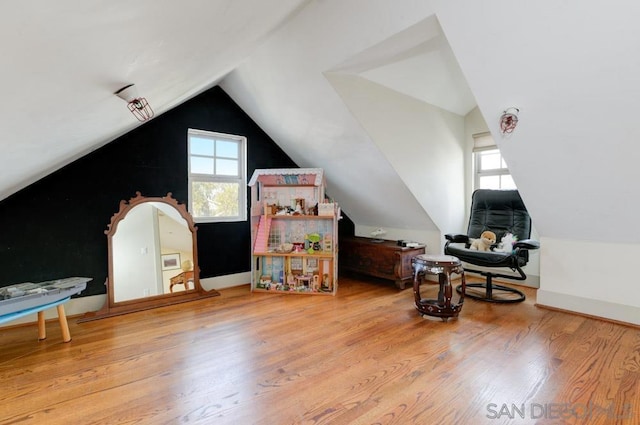 additional living space with light hardwood / wood-style flooring and vaulted ceiling