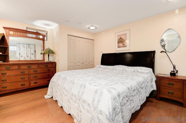 bedroom with light hardwood / wood-style flooring and a closet