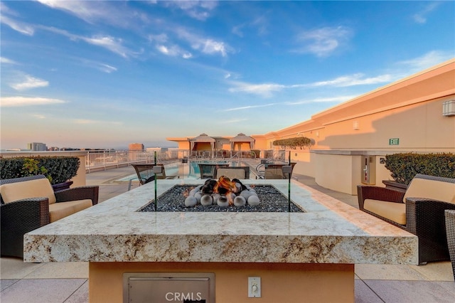 patio terrace at dusk featuring a fire pit