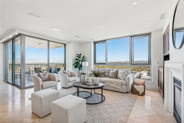 living area featuring expansive windows, light tile patterned floors, a fireplace, and plenty of natural light