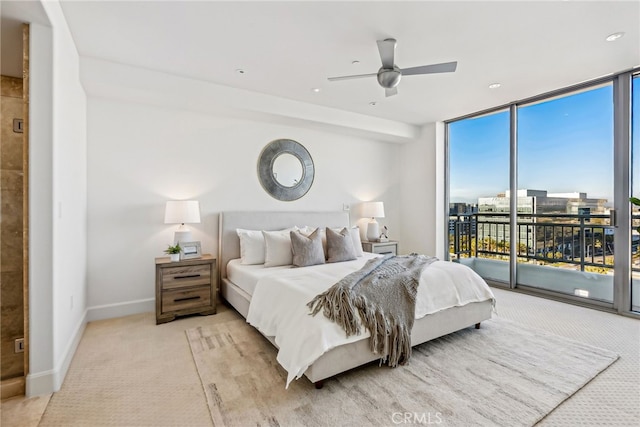 bedroom with baseboards, light colored carpet, access to outside, a view of city, and expansive windows