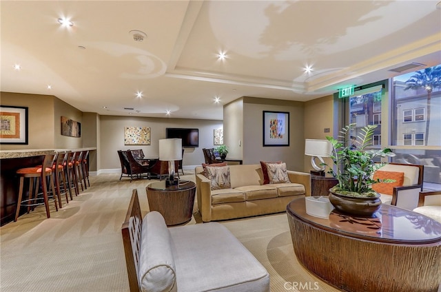 living room with recessed lighting, light carpet, baseboards, a bar, and a raised ceiling